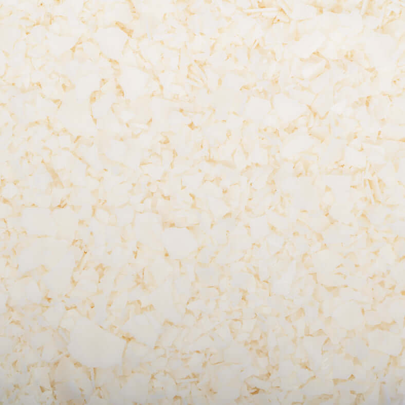 Gros plan d'une texture composée de nombreux petits flocons blancs fabriqués à partir de la cire de soja 444 Golden Brand de La Sultana Savonnerie. Les flocons varient en taille et en forme, créant un motif irrégulier mais uniforme. L'apparence générale est plate avec une couleur blanc crème uniforme, rappelant les bougies faites maison de haute qualité fabriquées au Québec.